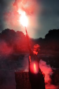 shallow focus photo of person holding flare